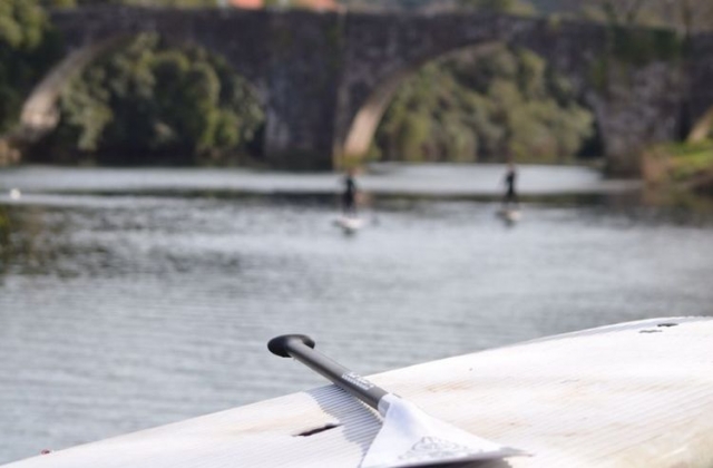 material de paddle surf con deportistas de fondo